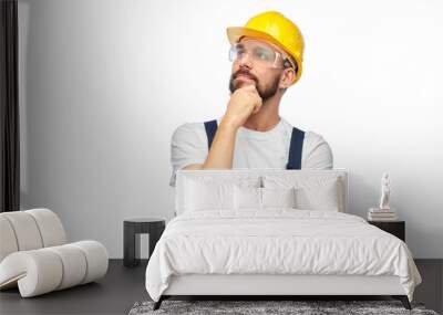 profession, construction and building - thinking male worker or builder in yellow helmet and goggles over white background Wall mural