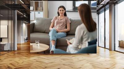 psychology, mental health and people concept - young woman patient and woman psychologist at psychotherapy session Wall mural