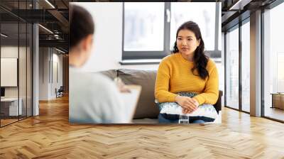 psychology and mental therapy concept - young asian woman patient and psychologist at psychotherapy session Wall mural