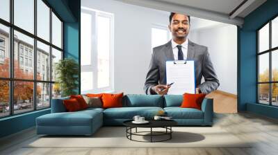 real estate business, mortgage and people concept - indian man realtor with pen and papers on clipboard over empty new apartment room background Wall mural