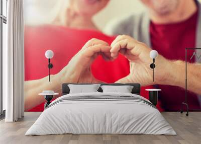 relationships, love and old people concept - close up of senior couple showing hand heart gesture Wall mural