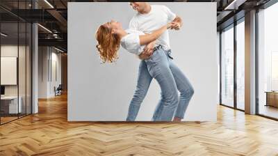 relationships and people concept - portrait of happy couple in white t-shirts dancing over grey background Wall mural