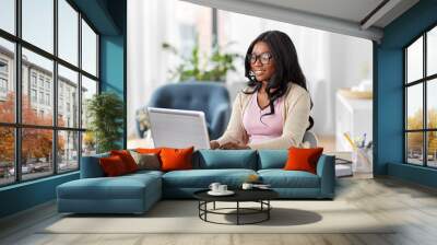 remote job, business and e-learning concept - happy smiling young african american woman in glasses with laptop computer working at home office Wall mural