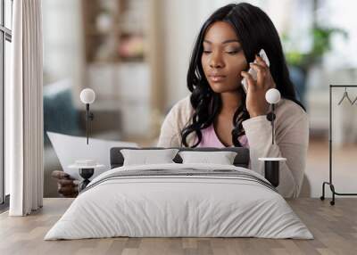 remote job, technology and people concept - african american young woman with laptop computer and papers working at home office and calling on smartphone Wall mural