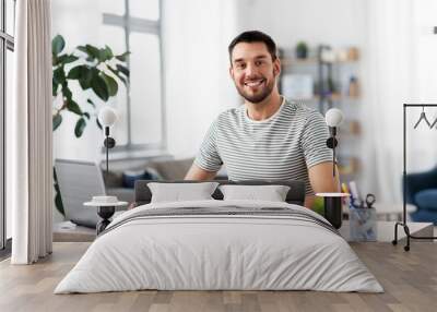 remote job, technology and people concept - young man with notebook and laptop computer working at home office Wall mural