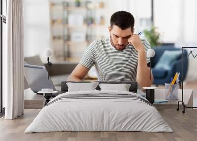 remote job and business concept - stressed man with papers, calculator and laptop computer working at home office Wall mural