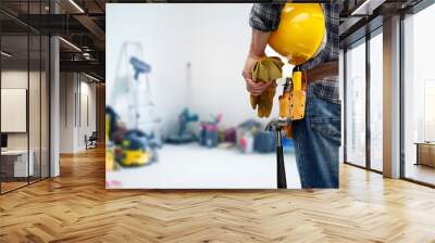 repair, construction and building - male worker or builder with helmet and working tools on belt over utility room background Wall mural