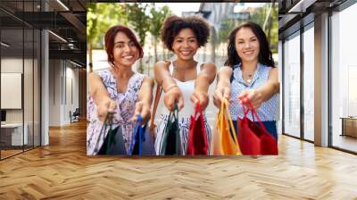 sale, consumerism and people concept - happy young women with shopping bags on city street Wall mural