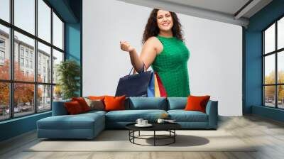 sale, outlet and consumerism concept - happy woman in green dress with shopping bags over grey background Wall mural