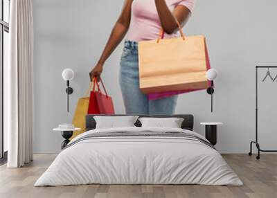 sale and people concept - happy smiling african american young woman with shopping bags over grey background Wall mural