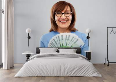 savings, finances and people concept - smiling senior woman holding hundred euro money banknotes Wall mural