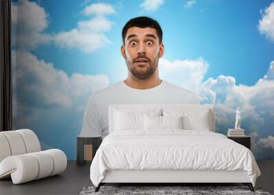 scared man in white t-shirt over sky background Wall mural