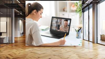 school, education and distance learning concept - female student with teacher on laptop computer screen having video call or online class at home Wall mural