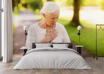 senior woman feeling sick at summer park Wall mural