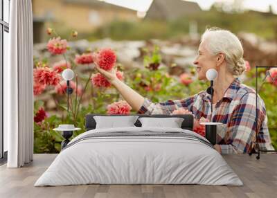 senior woman with flowers at summer garden Wall mural