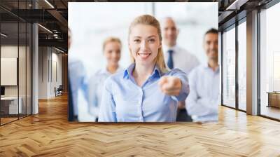 smiling businesswoman pointing finger on you Wall mural