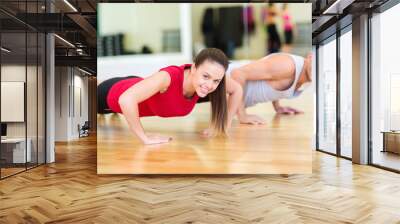 smiling couple doing push-ups in the gym Wall mural