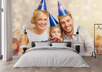 smiling family in blue hats blowing favor horns Wall mural