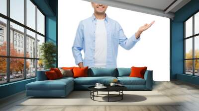 smiling man showing something on empty palm Wall mural