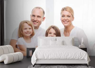 smiling parents and two little girls at home Wall mural