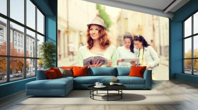 smiling teenage girls with city guides and camera Wall mural