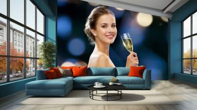 smiling woman holding glass of sparkling wine Wall mural