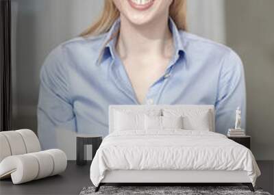 smiling woman holding papers in office Wall mural