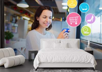 smiling woman with smartphone shopping online Wall mural