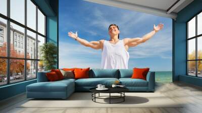 smiling young man on summer beach Wall mural