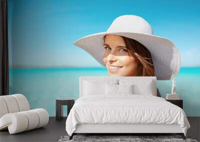 smiling young woman in sun hat on summer beach Wall mural