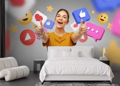 social media, blogging and people concept - happy smiling young woman or teenage girl in orange t-shirt showing thumbs up over internet icons on grey background Wall mural