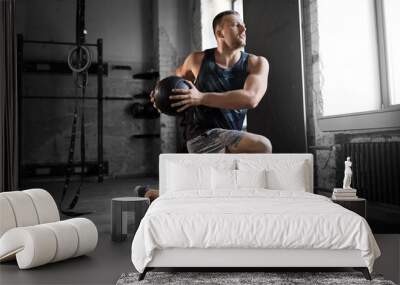 sport, bodybuilding, fitness and people concept - young man exercising with medicine ball in gym Wall mural