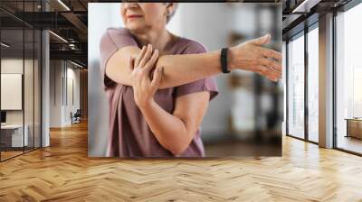 sport, fitness and healthy lifestyle concept - close up of senior woman exercising on mat and stretching arm at home Wall mural