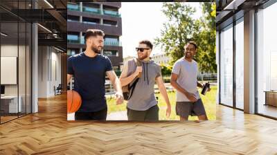 sport, leisure games and male friendship concept - group of men or friends going to play basketball outdoors Wall mural