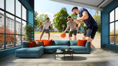 sport, leisure games and male friendship concept - group of men or friends playing street basketball Wall mural