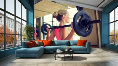 sporty woman exercising with barbell in gym Wall mural