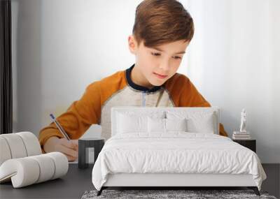 student boy with book writing to notebook at home Wall mural