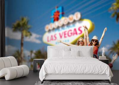 summer holidays, road trip and travel concept - happy friends driving in convertible car and waving hands over welcome to fabulous las vegas sign background Wall mural