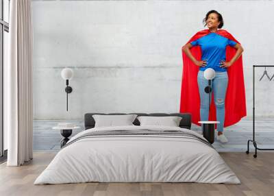 super power and people concept - happy african american young woman in superhero red cape over grey concrete background Wall mural