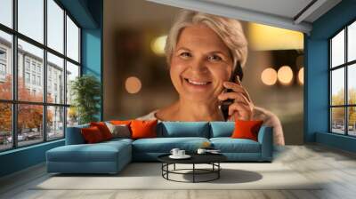 technology, communication and people concept - happy smiling senior woman calling on smartphone at home in evening Wall mural