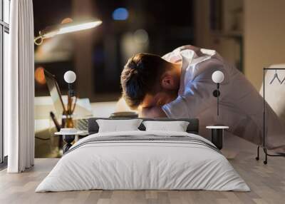 tired businessman lying on table at night office Wall mural