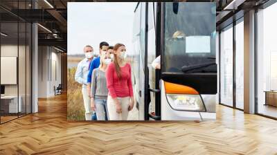 tourism and health concept - group of passengers wearing face protective medical mask for protection from virus disease boarding travel bus Wall mural