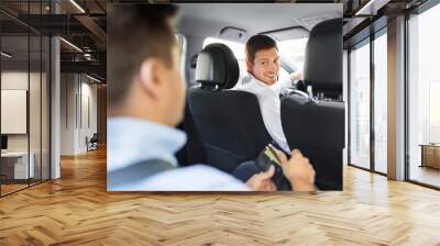 transportation, vehicle and payment concept - male car driver looking at passenger with credit card in wallet Wall mural