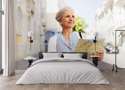 travel, tourism and retirement concept - senior woman or tourist with map on city street Wall mural