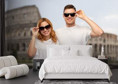 travel, tourism and vacation concept - happy couple in white t-shirts and sunglasses over coliseum in rome background Wall mural