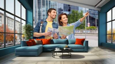 travel, tourism and vacation concept - happy couple of tourists with city guide, map and backpacks over city street background Wall mural