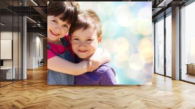 two happy kids hugging over blue lights background Wall mural