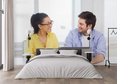 two smiling people with laptop in office Wall mural