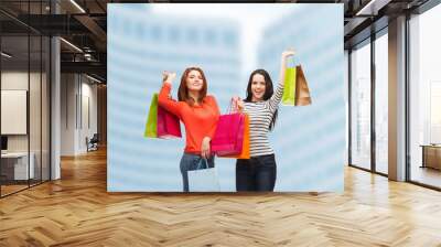 two smiling teenage girls with shopping bags Wall mural