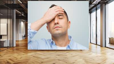 unhappy man with closed eyes touching his forehead Wall mural